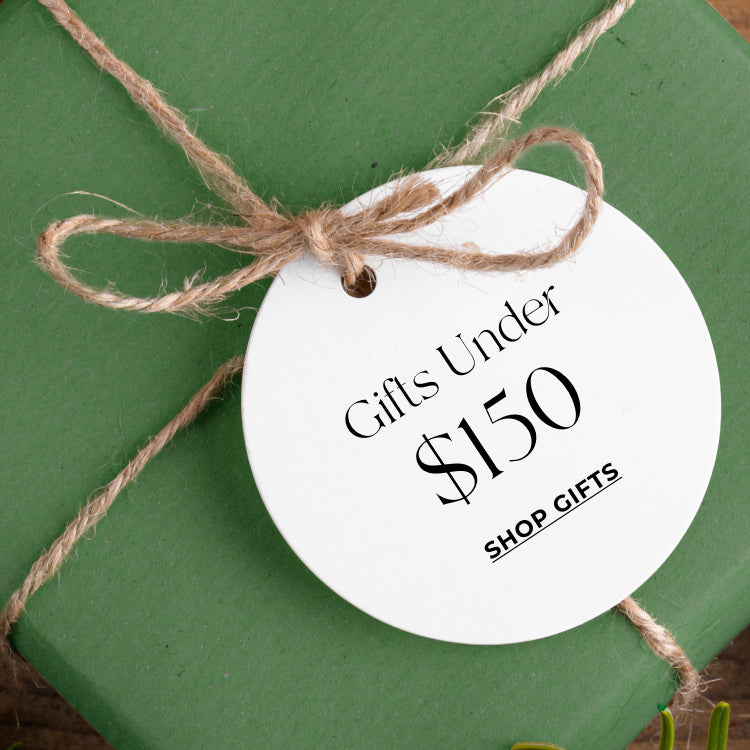 Green gift box with a white tag reading 'Gifts Under $150' on a green background.Shop gifts under $150.