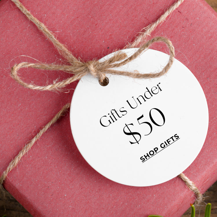 Gift tag on a red gift box with 'Gifts Under $50 text.Shop Gifts under $50.