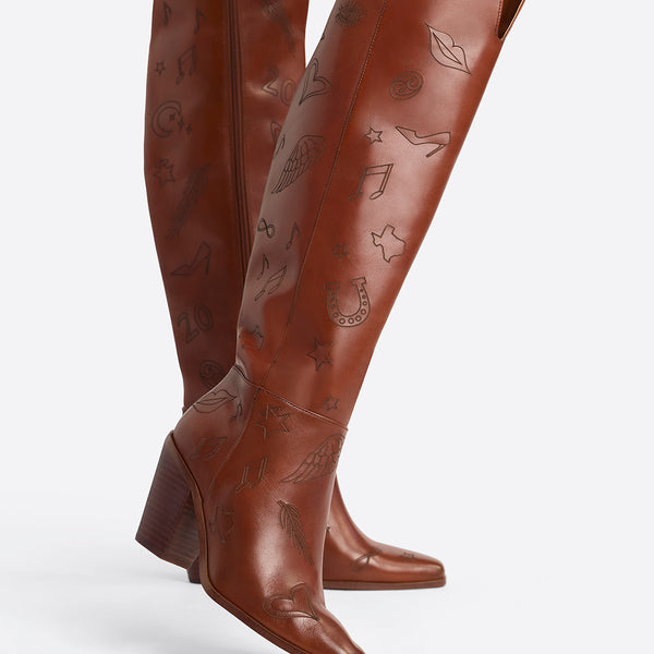 Brown knee-high boots with decorative patterns on a white background