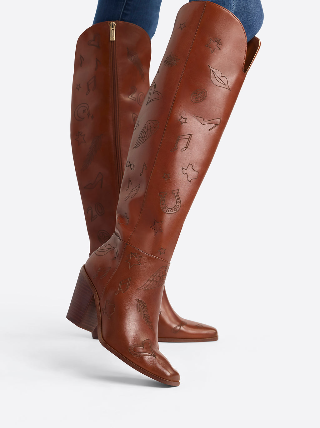 Brown knee-high boots with decorative patterns on a white background
