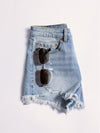 Denim skirt with sunglasses on a light gray background