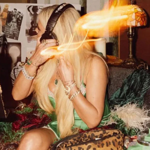 Jessica Simpson sitting on a couch in a cozy room with candles and a lamp.
