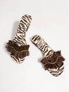 Zebra print slippers with brown ruffles on a white background